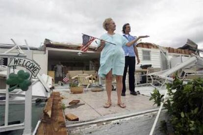 Una mujer y su hijo contemplan los restos de su casa, arrasada por el huracán Wilma, en la localidad de Davie, Florida.