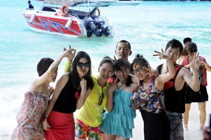 A group of Chinese tourists enjoying a day on the beach in Thailand.