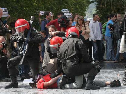 Varios <i>ertzainas</i> detienen a un joven durante los incidentes de San Sebastián.