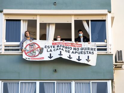 Los vecinos de Carlos Haya, 65, en Málaga, descuelgan la pancarta en contra de la apertura de una casa de apuestas en los bajos, tras conseguir que ese negocio no se instale allí.