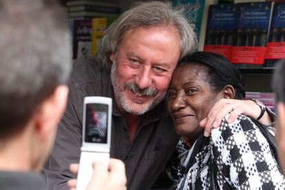 El escritor Julio Llamazares se fotografía con una lectora en la Feria del Libro de Madrid.