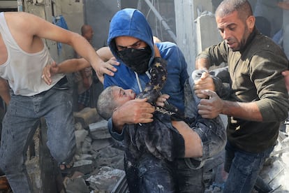  Un hombre carga a una víctima de un bombardeo israelí en Jan Yunis, en el sur de la Franja, este martes.