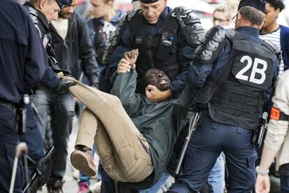 Un migrante se resiste a ser evacuado por la policía durante el desmantelamiento de un campamento temporal de inmigrantes, en la avenida Flandre en el norte de París (Francia).