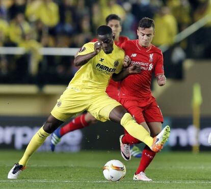 El defensa marfileño del Villarreal, Eric Bailly (i), lucha el balón con el brasileño Coutinho, del Liverpool.