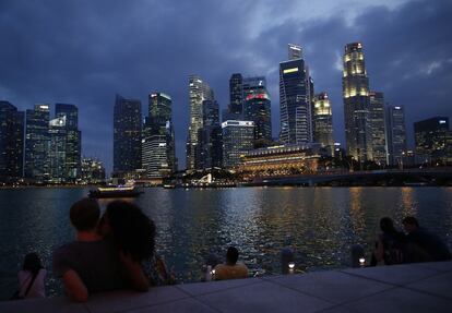 A couple kiss as they watch the city lights from across the Marina Bay at the central business district in Singapore, March 13, 2015. REUTERS/Edgar Su (SINGAPORE - Tags: SOCIETY CITYSCAPE BUSINESS)