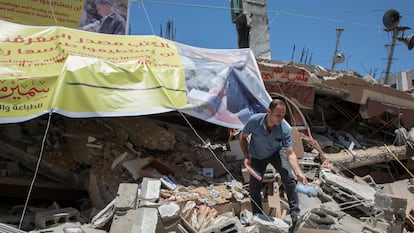 Um palestino resgata livros entre os escombros da livraria Mansur, destruída por um bombardeio israelense, em maio em Gaza.