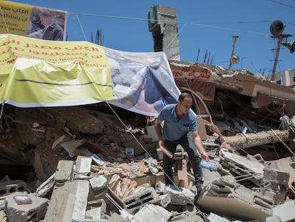 Um palestino resgata livros entre os escombros da livraria Mansur, destruída por um bombardeio israelense, em maio em Gaza.