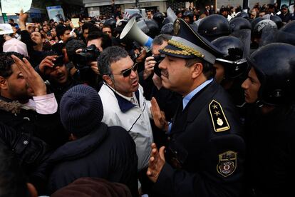 Un oficial de policía tunecino intenta calmar a los manifestantes que protestan en la capital contra el nuevo gobierno.