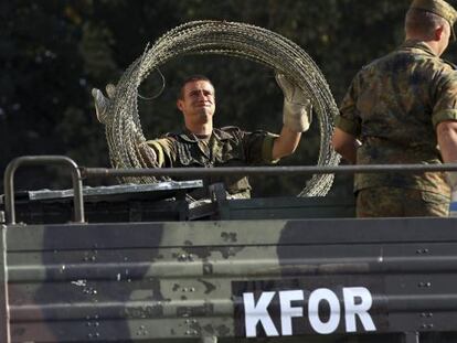 Soldados alemanes de la KFOR descargan alambrado en el principal puente que divide la ciudad de Mitrovica, Kosovo.