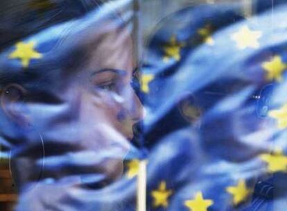 Una mujer mira por la ventanilla de un tranvía las banderas de manifestantes proeuropeos ayer en Belgrado.