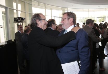 El cantautor catalán Joan Manuel Serrat saluda a Juan Luis Cebrián, presidente del Grupo Prisa.