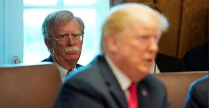 Trump com o assessor da Casa Branca, John Bolton, ao fundo.