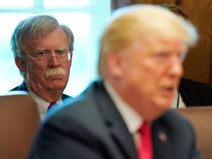 Trump com o assessor da Casa Branca, John Bolton, ao fundo.