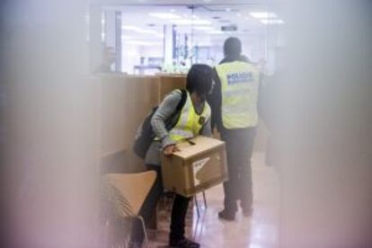 Una policía transporta una caja en el registro a unas dependencias del Ayuntamiento de Sabadell.