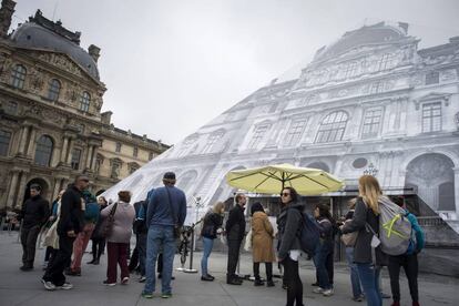 Turistas leen los carteles que indican que el Museo del Louvre permanecer&aacute; cerrado para proteger las obras de zonas en riesgo de verse inundadas.