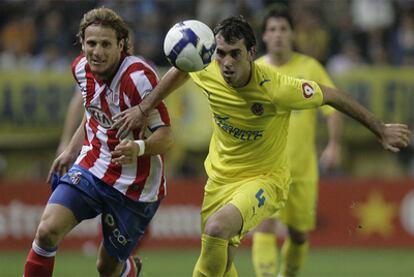 Godín protege el balón ante el acoso de Forlán en un partido de la pasada temporada.