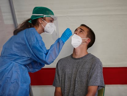 Una sanitaria realiza un test PCR a un joven, en el barrio Mendillori de Pamplona, este jueves.