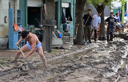 Un hombre limpia el lodo con una pala de una calle tras las inundaciones en Bahía Blanca, el sábado pasado.