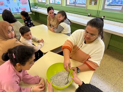 Madres y alumnos del CEIP Gumersindo Azcárate (León), compartiendo una actividad formativa en el Aula de la Naturaleza del centro. En la imagen, aprenden a preparar sales minerales de lavanda con hierbas provenientes del huerto escolar.