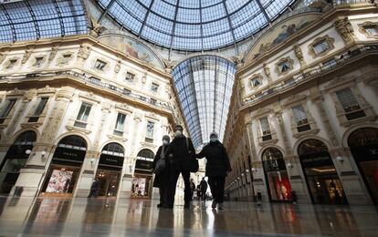 Tres personas con mascarillas pasean por las Galería Vittorio Emanuele II, en Milán.