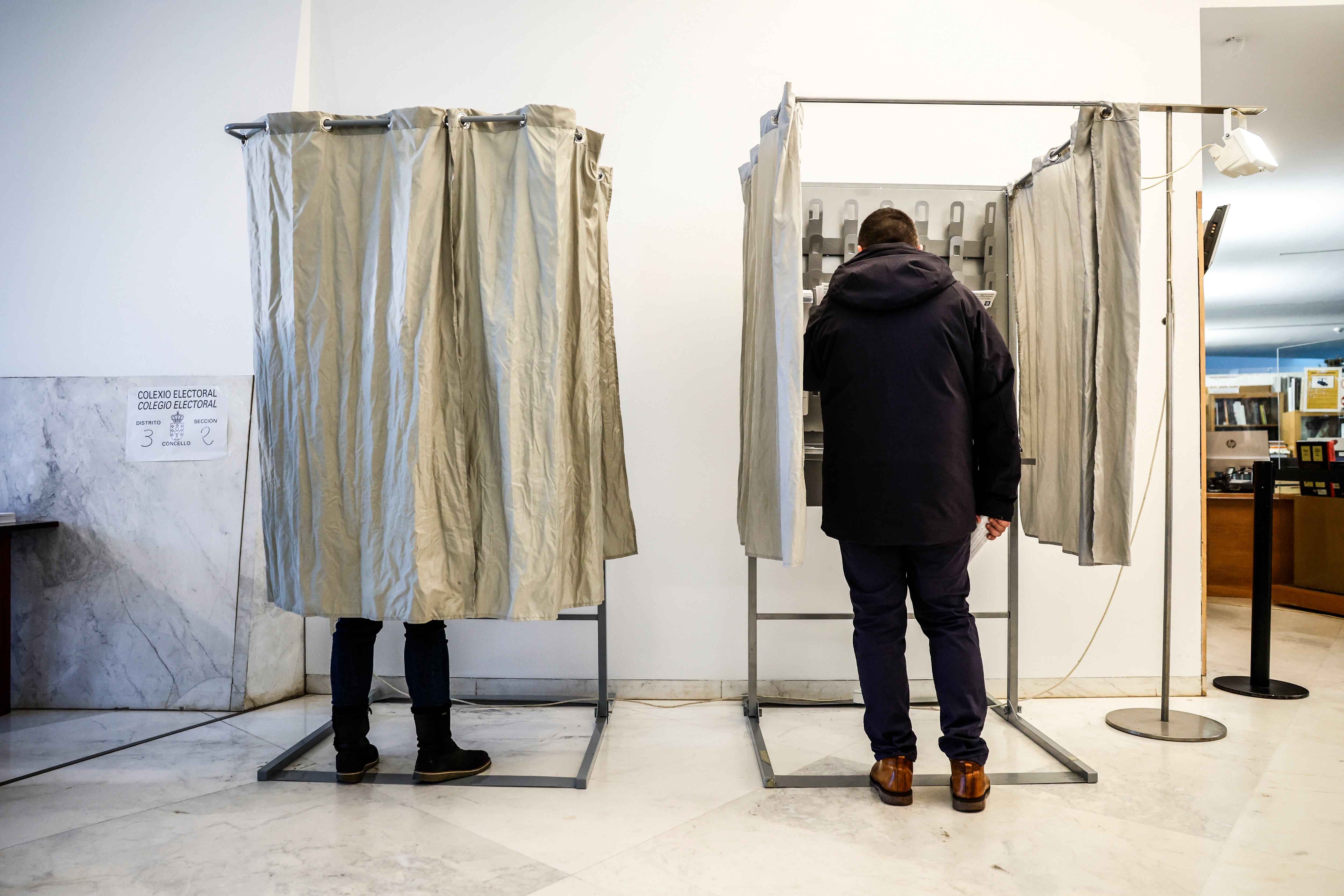 Dos personas en las cabinas de votación, este domingo en el Centro Galego de Arte Contemporánea, en Santiago de Compostela.