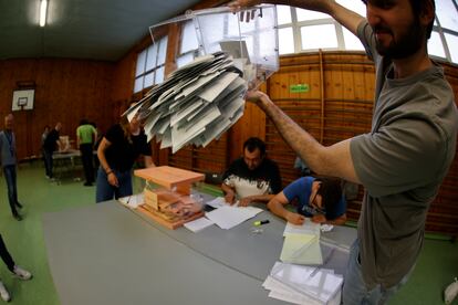 Los miembros de una mesa electoral proceden a la apertura de las urnas para el recuento de votos, tras el cierre de los colegios electorales este domingo en Bilbao.