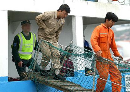 Dos marineros del <i>Wisteria,</i> cuando fueron detenidos, el 28 de mayo, para declarar en la comisaría de Ribeira.