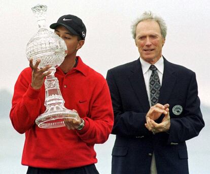 El actor Clint Eastwood aplaude mientras Tiger Woods besa el trofeo del torneo AT&T Pebble Beach National Pro- am, de la PGA