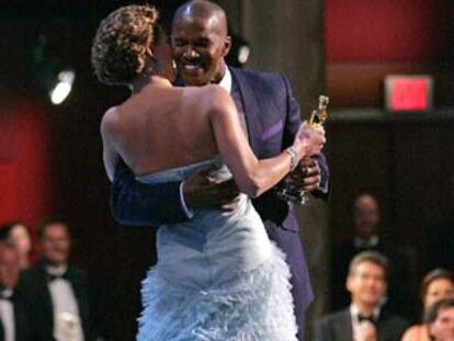 Jamie Foxx abraza a Charlize Theron tras recoger el Oscar al mejor actor protagonista por <i>Ray.</i>