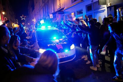 Aficionados franceses hacen un pasillo a un coche de Policía en las calles de París.