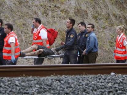 Personal de emergencias retiranun herido del lugar del accidente del tren.  