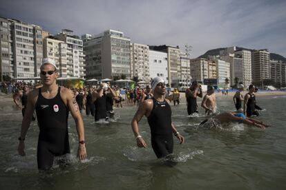 Varios nadadores entran en el agua en la playa de Copacabana para participar en la maratón masculina de natación.