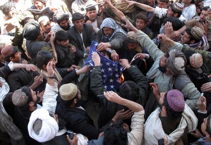 Afganos queman una bandera de EE UU en Helmand.