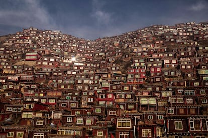Las viviendas, en su mayoría de madera roja, cubren completamente una de las laderas de las montañas de Sichuan que rodean al Instituto Larung Wuming.