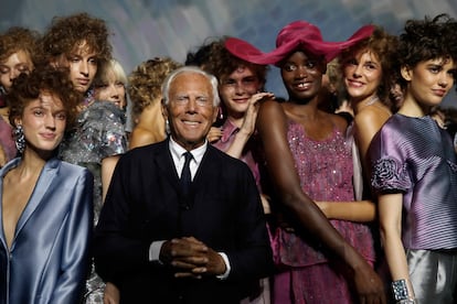 Armani rodeado de modelos en un desfile de 2019.