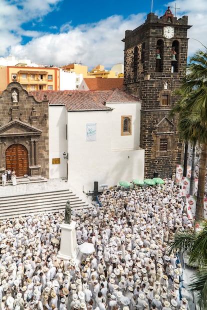 En la plaza de España de Santa Cruz de La Palma, renombrada por un día como plaza de La Habana, el Carnaval de Los Indianos despliega cada lunes de carnaval un espectáculo único: vestimentas decimonónicas de lino blanco, gentes cubiertas de talco y una explosión de música cubana que revive el legado de los migrantes retornados de América. Esta festividad, declarada de Interés Turístico en 2022, fusiona el cachondeo intrínseco de los palmeros con la memoria colectiva que los une. 