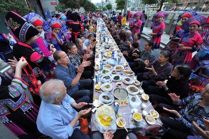 Los aldeanos aplauden en una reunión para disfrutar de una comida juntos a lo largo de una calle para celebrar un festival étnico de Zhuang en Baise, región autónoma de Zhuang de Guangxi, China.  