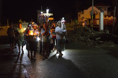 Un grupo de vecinos pasean rezando el rosario por las calles de Tacloban.