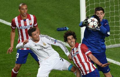 O goleiro do Atlético, Thibaut Courtois, agarra a bola em um lance pressionado por Cristiano Ronaldo.