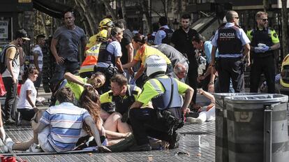 Los servicios de emergencia atienden a algunos de los heridos en La Rambla, Barcelona, tras el atentado.