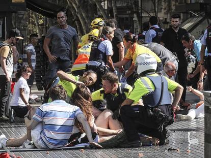 Los servicios de emergencia atienden a algunos de los heridos en La Rambla, Barcelona, tras el atentado.