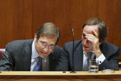 El primer ministro luso, Pedro Passos Coelho (i), conversa con el ministro de Asuntos Exteriores, Paulo Portas, durante el debate por las dos mociones de censura presentadas por el Partido Comunista (PCP y el Bloque de Izquierda (BI), en Lisboa, Portugal, el pasado 4 de octubre. EFE/Archivo