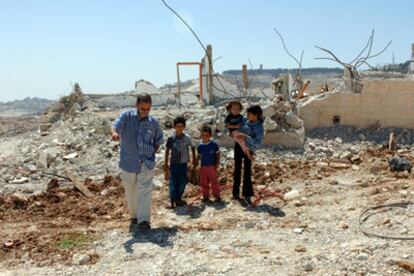 Meir Margalit, acompañado de un grupo de niños, entre las ruinas de viviendas palestinas derribadas por los israelíes.