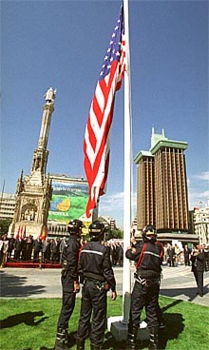 Unos bomberos del Ayuntamiento izan la bandera de Estados Unidos.