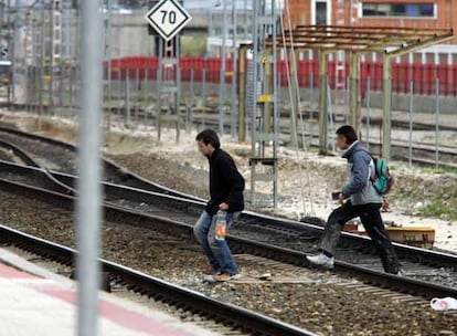 Dos toxicómanos cruzan las vías de la estación de San Cristóbal Industrial.