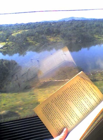 Un libro, su reflejo, el paisaje a través de la ventanilla... una imagen de Lola Elkin, galardonada también con un cuarto premio.