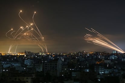 Cohetes iluminan el cielo nocturno mientras son disparados hacia Israel desde Beit Lahia (a la izquierda). en el norte de la Franja de Gaza, y desde Israel a Gaza.