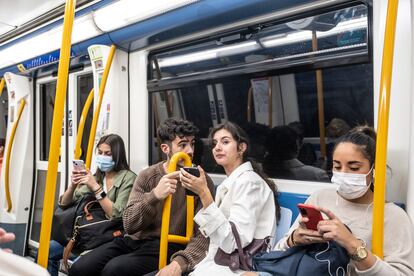 Una pareja conversa sin mascarilla en un vagón del metro de Madrid. 