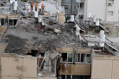 Bomberos y personal de rescate inspeccionan los daños en un edificio afectado en Tel Aviv por ataque con cohetes desde la franja de Gaza, este viernes. 