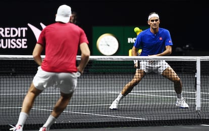 Jack Sock y Roger Federer, frente a frente cerca de la red en un intercambio frenético de golpes.